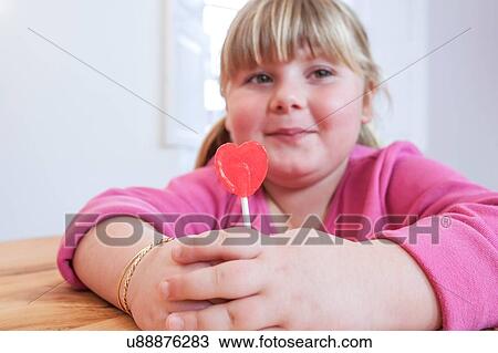 Portrait of overweight girl holding heart shape lollipop View Large Photo Image Stock Image - Portrait of overweight girl holding heart shape lollipop. Fotosearch