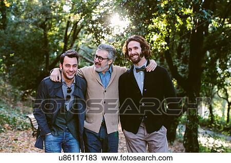 Portrait of proud mature man and two adult sons in park View Large Photo Image Stock Image - Portrait of proud mature man and two adult sons in park. Fotosearch