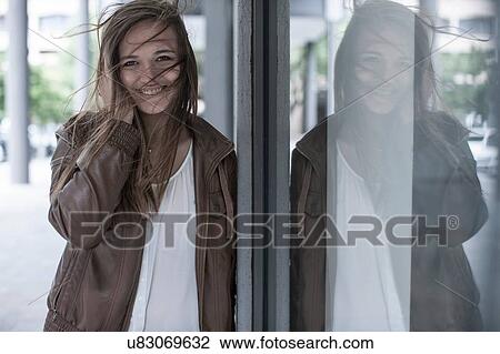 Portrait of teenage girl with flyaway hair leaning against city window View Large Photo Image Stock Image - Portrait of teenage girl with flyaway hair leaning against city window. Fotosearch