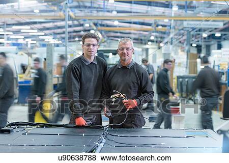 Stock Photo - Portrait of workers on motorhome production line. Fotosearch
