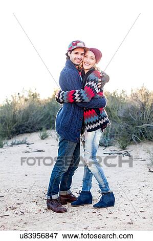 Stock Photo - "Portrait of young couple hugging, outdoors". Fotosearch