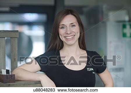 Portrait of young female waitress in cafe leaning against shelf View Large Photo Image Stock Image - Portrait of young female waitress in cafe leaning against shelf. Fotosearch
