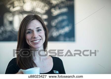 Portrait of young female waitress holding coffee in cafe View Large Photo Image Stock Photo - Portrait of young female waitress holding coffee in cafe. Fotosearch