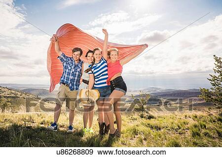 Portrait of young man and female friends holding up blanket on windy hill, Bridger, Montana, USA View Large Photo Image Stock Photo - Portrait of young man and female friends holding up blanket on windy hill, Bridger, Montana, USA. Fotosearch