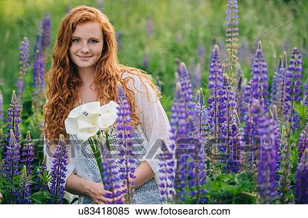 Portrait of young woman amongst purple wildflowers holding bunch of lilies View Large Photo Image Stock Photography - Portrait of young woman amongst purple wildflowers holding bunch of lilies. Fotosearch
