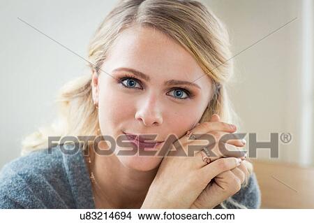 Picture - Portrait of young woman hand on cheek looking at camera smiling. Fotosearch