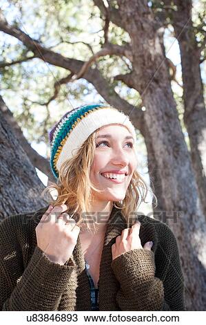 Stock Image - "Portrait of young woman outdoors, smiling". Fotosearch