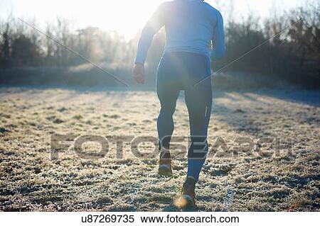 Rear view of runner running on frosty grass View Large Photo Image Stock Photography - Rear view of runner running on frosty grass. Fotosearch