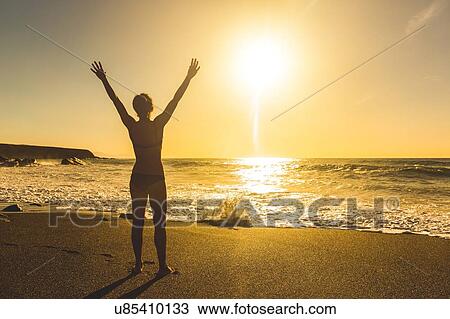 Rear view of silhouetted young woman on beach at sunset, Ajuy, Fuerteventura, Spain View Large Photo Image Stock Image - Rear view of silhouetted young woman on beach at sunset, Ajuy, Fuerteventura, Spain. Fotosearch
