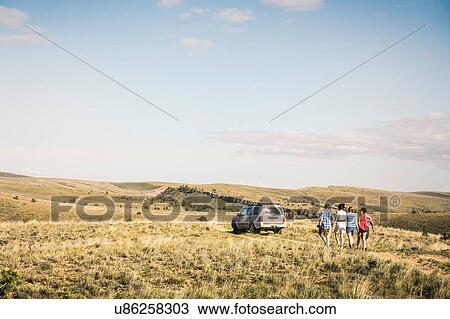 Rear view of teenage and young adult friends walking on dirt track to off road vehicle, Bridger, Montana, USA View Large Photo Image Stock Image - Rear view of teenage and young adult friends walking on dirt track to off road vehicle, Bridger, Montana, USA. Fotosearch