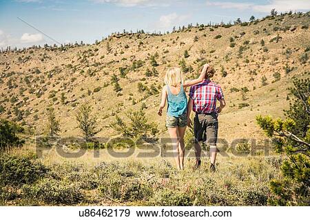 Rear view of teenage girl and boyfriend walking in hills, Bridger, Montana, USA View Large Photo Image Stock Photo - Rear view of teenage girl and boyfriend walking in hills, Bridger, Montana, USA. Fotosearch