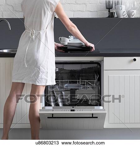 Rear view of woman loading dishes into dishwasher View Large Photo Image Stock Image - Rear view of woman loading dishes into dishwasher. Fotosearch