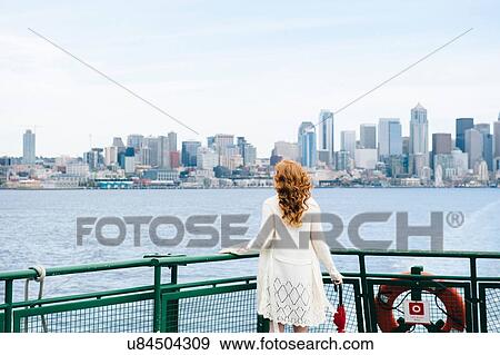 "Rear view of woman looking at city skyline from passenger ferry on Puget Sound, Seattle, USA" View Large Photo Image Stock Photo - "Rear view of woman looking at city skyline from passenger ferry on Puget Sound, Seattle, USA". Fotosearch