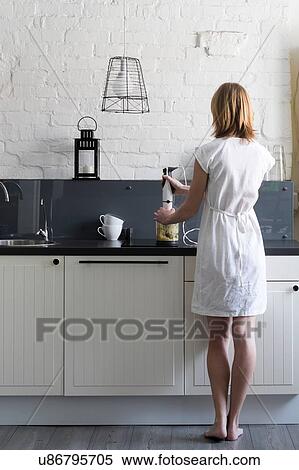 Rear view of woman using blender at kitchen counter View Large Photo Image Stock Photography - Rear view of woman using blender at kitchen counter. Fotosearch