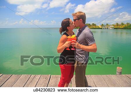 "Romantic couple kissing on waterfront pier, St. Georges Caye, Belize, Central America" View Large Photo Image Stock Image - "Romantic couple kissing on waterfront pier, St. Georges Caye, Belize, Central America". Fotosearch