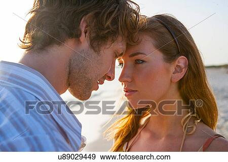 Stock Photo - Romantic young couple face to face on beach, Majorca, Spain. Fotosearch
