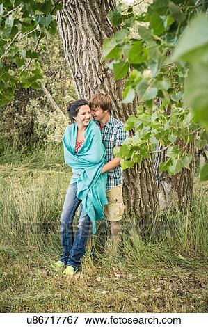 Romantic young couple leaning against rural tree View Large Photo Image Stock Photo - Romantic young couple leaning against rural tree. Fotosearch