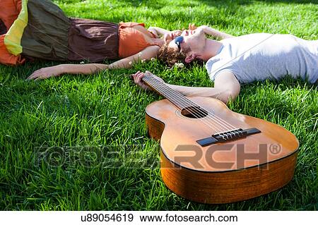 Romantic young couple lying on garden lawn View Large Photo Image Stock Photo - Romantic young couple lying on garden lawn. Fotosearch