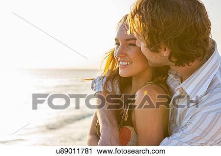 Stock Image - Romantic young couple on sunlit beach, Majorca, Spain. Fotosearch