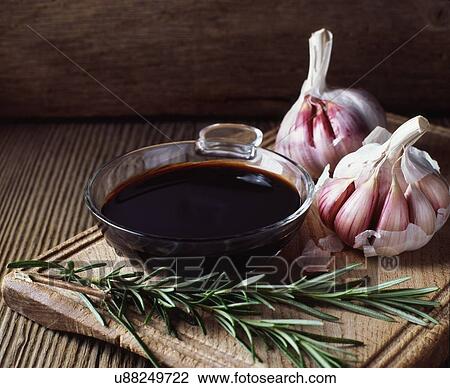 Stock Image - Rosemary, garlic bulbs and bowl of balsamic vinegar. Fotosearch