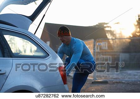 Runner with leg raised on car boot tying shoelace View Large Photo Image Stock Image - Runner with leg raised on car boot tying shoelace. Fotosearch
