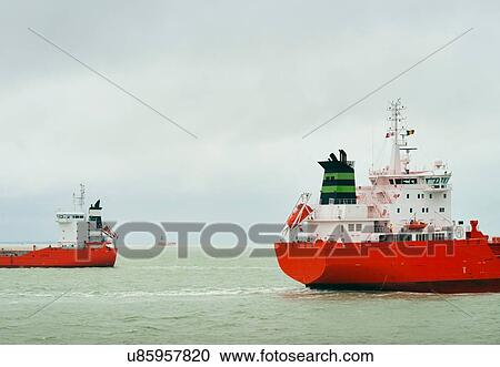 Stock Image - Ships with red hull pass each other on the North Sea. Fotosearch