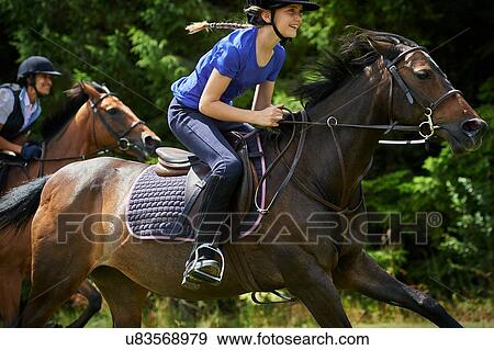 Stock Photo - Side view of girl riding horse smiling. Fotosearch