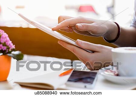 Side view of young womans hands using digital tablet View Large Photo Image Stock Image - Side view of young womans hands using digital tablet. Fotosearch