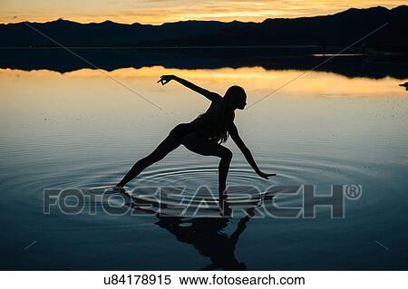 "Silhouetted female dancer poised in lake at sunset, Bonneville Salt Flats, Utah, USA" View Large Photo Image Stock Photography - "Silhouetted female dancer poised in lake at sunset, Bonneville Salt Flats, Utah, USA". Fotosearch