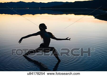 "Silhouetted female dancer poised with open arms in lake at sunset, Bonneville Salt Flats, Utah, USA" View Large Photo Image Picture - "Silhouetted female dancer poised with open arms in lake at sunset, Bonneville Salt Flats, Utah, USA". Fotosearch