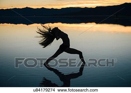 "Silhouetted female dancer throwing back her long hair in lake at sunset, Bonneville Salt Flats, Utah, USA" View Large Photo Image Picture - "Silhouetted female dancer throwing back her long hair in lake at sunset, Bonneville Salt Flats, Utah, USA". Fotosearch