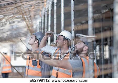 Site manager and builders looking up at steel rod structure on construction site View Large Photo Image Stock Image - Site manager and builders looking up at steel rod structure on construction site. Fotosearch