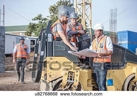 Stock Photo - Site manager explaining to steamroller drivers about blueprint on construction site. Fotosearch