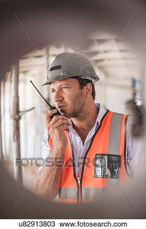 Site manager using walkie talkie on construction site View Large Photo Image Stock Image - Site manager using walkie talkie on construction site. Fotosearch
