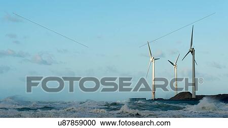 Stock Image - Stormy ocean waves splashing harbour wall and wind turbines, Boulogne-sur-Mer, Pas de Calais, France. Fotosearch