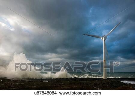 Picture - Stormy sky and ocean waves splashing harbour wall and wind turbine, Boulogne-sur-Mer, Pas de Calais, France. Fotosearch