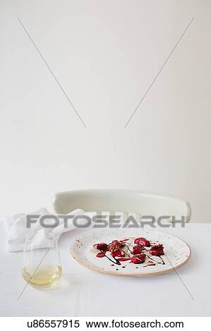 Stock Photography - Table with plate of red beet ravioli with blue cheese and coffee sauce. Fotosearch