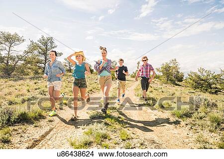 Teenage girl and adult friends running on dirt track, Bridger, Montana, USA View Large Photo Image Picture - Teenage girl and adult friends running on dirt track, Bridger, Montana, USA. Fotosearch