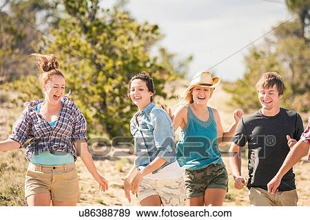 Teenage girl and adult friends running and laughing, Bridger, Montana, USA View Large Photo Image Stock Photo - Teenage girl and adult friends running and laughing, Bridger, Montana, USA. Fotosearch