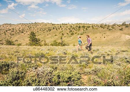 Teenage girl and boyfriend running in hills, Bridger, Montana, USA View Large Photo Image Stock Image - Teenage girl and boyfriend running in hills, Bridger, Montana, USA. Fotosearch
