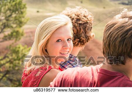 Teenage girl looking over her shoulder between male friends, Bridger, Montana, USA View Large Photo Image Stock Photo - Teenage girl looking over her shoulder between male friends, Bridger, Montana, USA. Fotosearch