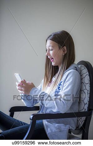 Stock Photograph - Teenage girl using a smartphone. Fotosearch