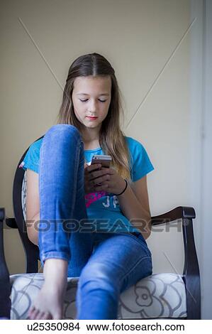 Picture - Teenage girl using smartphone. Fotosearch
