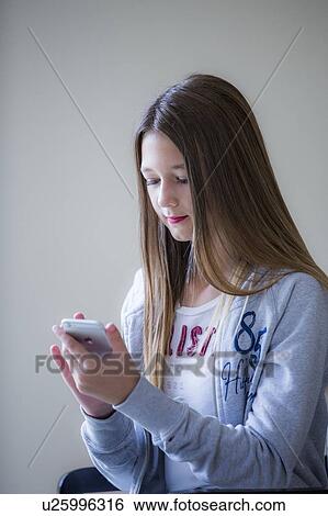 Stock Photograph - Teenage girl using smartphone. Fotosearch
