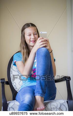 Stock Photography - Teenage girl using smartphone. Fotosearch