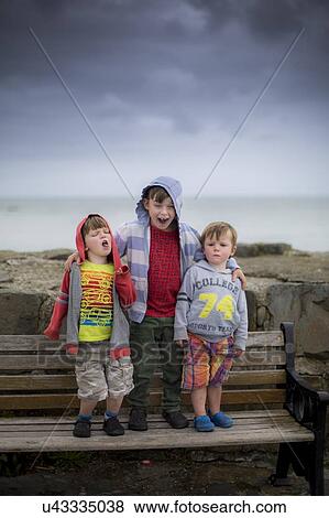 Three boys on bench View Large Photo Image Stock Photo - Three boys on bench. Fotosearch
