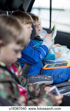 Three brothers in car with digital device View Large Photo Image Stock Image - Three brothers in car with digital device. Fotosearch