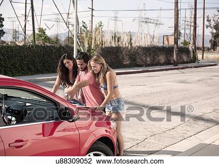 Three young adult friends reading roadmap on red car bonnet, Los Angeles, California, USA View Large Photo Image Stock Image - Three young adult friends reading roadmap on red car bonnet, Los Angeles, California, USA. Fotosearch
