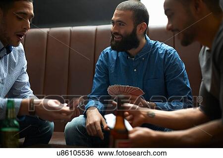 Three young adult male friends playing card game in traditional UK pub View Large Photo Image Stock Photograph - Three young adult male friends playing card game in traditional UK pub. Fotosearch