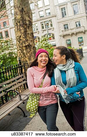 Twins walking and chatting in park View Large Photo Image Stock Photo - Twins walking and chatting in park. Fotosearch